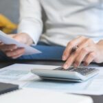 Personne qui paye ses impôts avec calculatrice