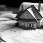Maison miniature disposée sur des plans de construction
