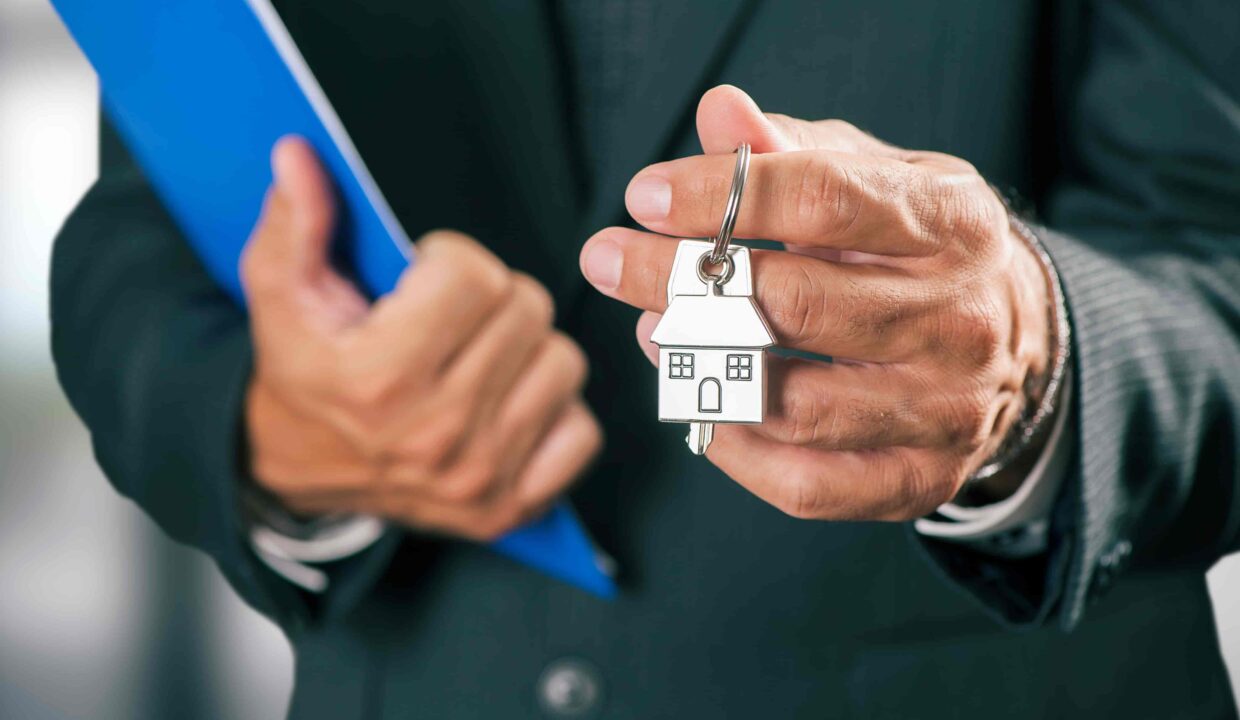 A man holding an apartment key in his hand.