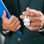 A man holding an apartment key in his hand.